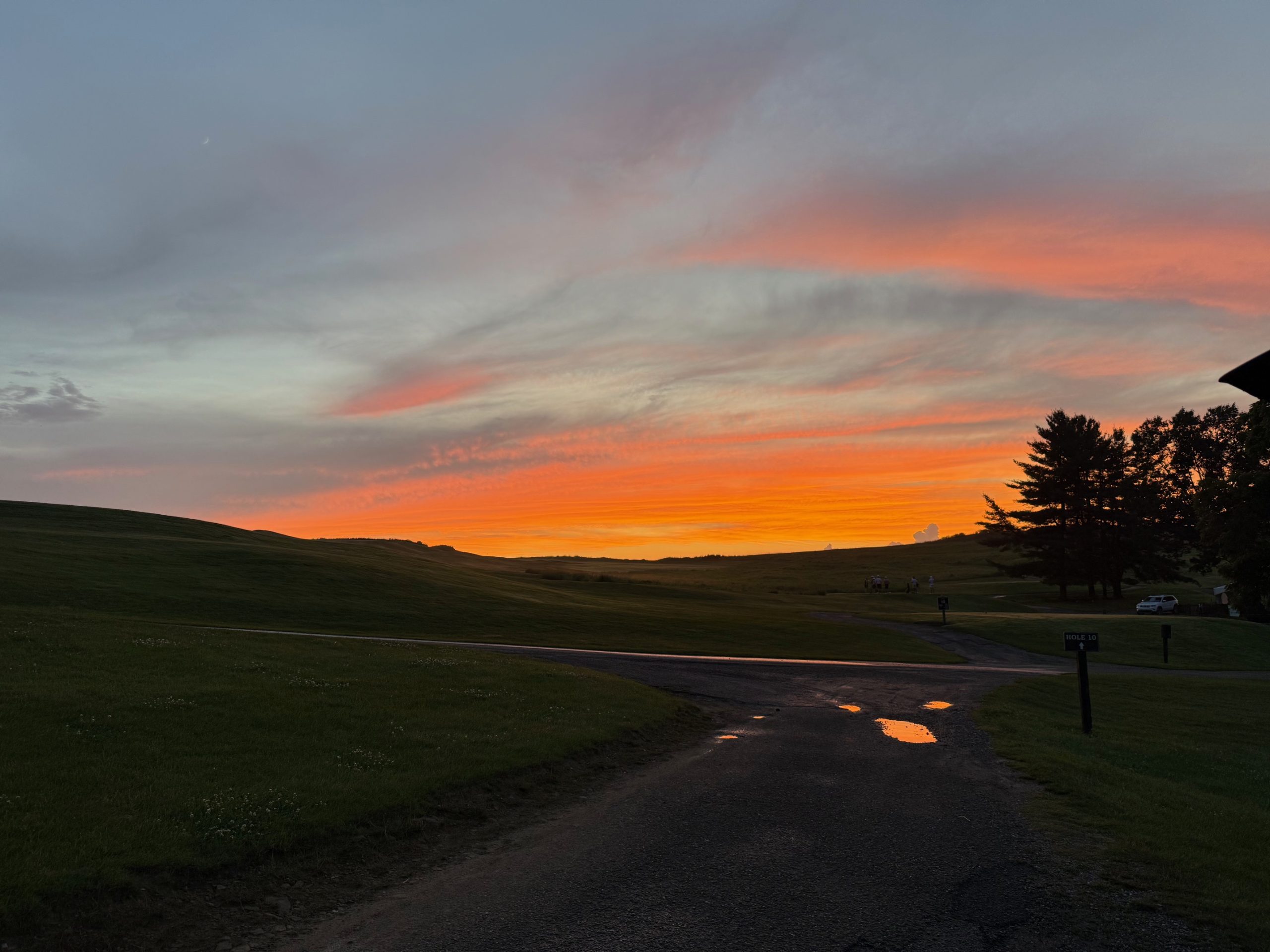 sunset at the golf course over some puddles